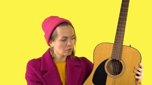 Crazy Woman with Strange Look, Pink Comb Combing Guitar, Surrealism on Yellow Background. Psychopath, Guitar Tuning, Advertising Concept