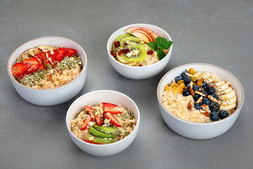 Oatmeal bowls with delicious fruits and fresh berries on light background.