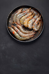 Raw pacific white prawns on dark background. Fresh seafood concept.