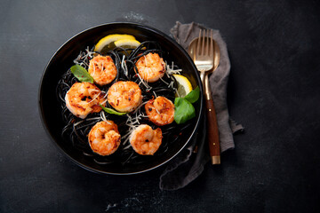 Spaghetti with shrimps and parmesan on dark background. Tasty appetizings seafood pasta.
