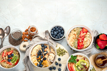 Oatmeal bowls with delicious fruits and fresh berries on light background.