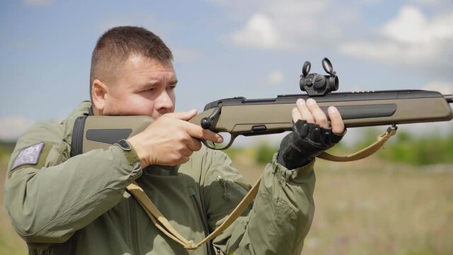 The shooter shoots from the rifle. European man with rifle, close-up