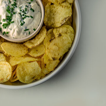 Top Down View Of A Bowl Of Potato Crisps With Sour Cream And Chive Dip With Copy Space