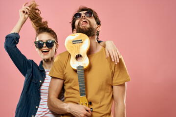man and woman ukulele fun lifestyle pink background fashion