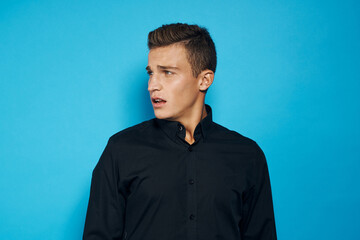 Obraz premium Cute man in black shirt emotions studio blue background