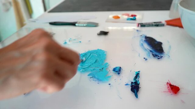 Artist mixing paint on a palette