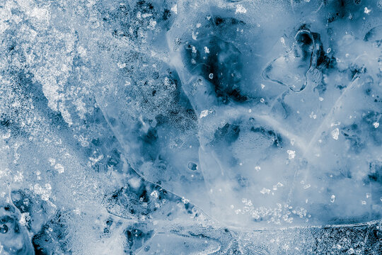 Ice texture background. Textured, blue tone, cold, frosty surface of ice block on black background.