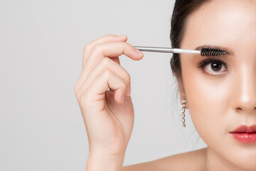 Close up face Asian woman applying mascara brush on eyelash. Applying cosmetic make up eyelash...
