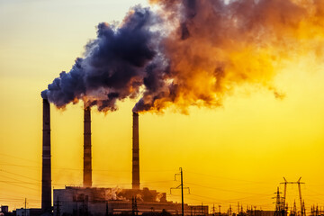 Sunset over the industrial city.Factory chimneys smoke.Environmental problem of environmental and...