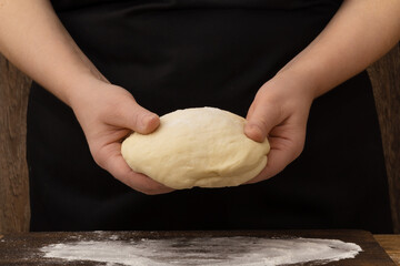 Female hands with yeast dough for pizza or pastry