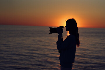 woman photographer near the sea at sunset landscape macro photography