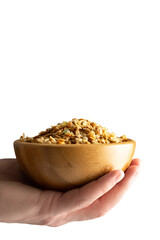 full cup of muesli in hand on white background