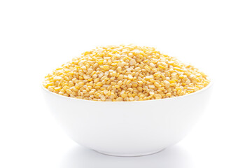 Close up of Organic yellow Gram (Vigna radiata) or split yellow moong dal inside a ceramic white...