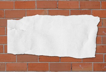 note white ripped paper on brick red background