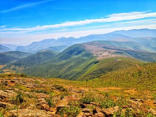 Naklejka premium Mountain range with visible silhouettes through the morning colorful fog.