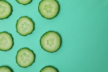 Fresh ripe cucumber slices on mint background