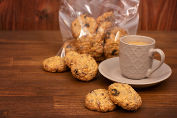 oatmeal cookies. Copy space, close-up, brown background. Oatmeal cookies on the table with a cup of coffee.