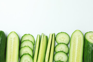 Ripe cucumber and slices on white background