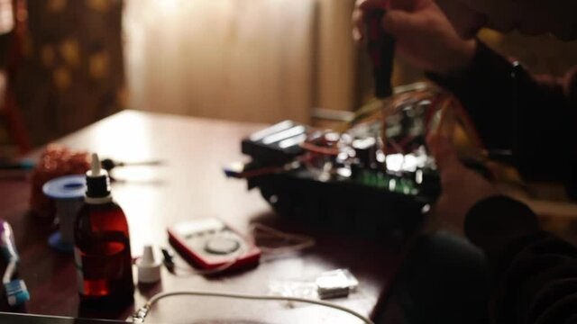DIY, the machine on electronic control. Home experiments, robotics, smart engineer. Toy for the child. A man fixes an electronic device. soldering iron, wires, motherboard