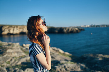 Fototapeta na wymiar woman in mountains near blue lake summer vacation model glasses landscape