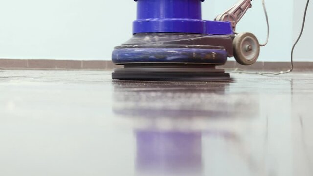 close up , the cleaner washes a pier with a professional polisher machine. Cleaning floor in office building lobby