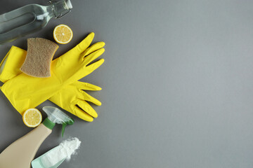 Cleaning concept with eco friendly cleaning tools and lemons on gray background