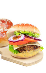 Cheeseburger on a cutting board isolated on a white background. Hamburger with cheese. Burger isolated. Tasty dinner. Vertical orientation