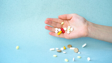 Hand dropping pills on the table. Image with selective focus