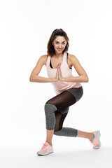 Fototapeta premium Young woman in sportswear is doing exercises. Beautiful smiling brunette. Full height. Active lifestyle. Isolated on white background. Vertical.