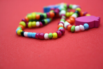 A bracelet made of beads on a red background.