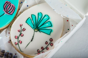 Sweet, tasty and colored and painted gingerbread cookies on a light background in a light box with a sprig of lavender. The dessert is sweet. Selective focus. The concept of sweet and cooking