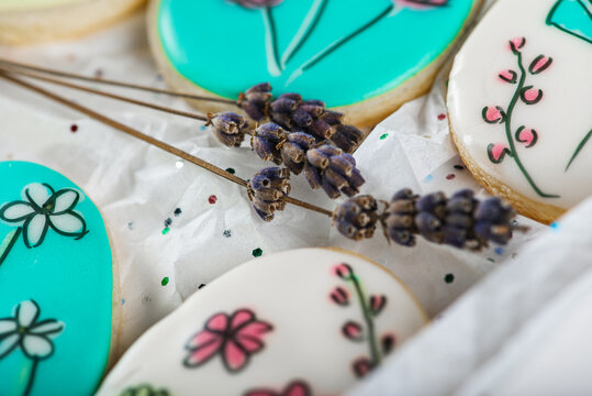 Sweet, tasty and colored and painted gingerbread cookies on a light background in a light box with a sprig of lavender. The dessert is sweet. Selective focus. The concept of sweet and cooking