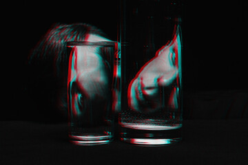 portrait of a man looking through two glasses of water