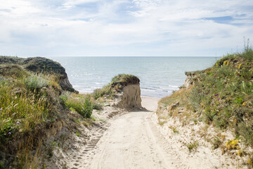 Fototapeta na wymiar Road through the dunes to the sea
