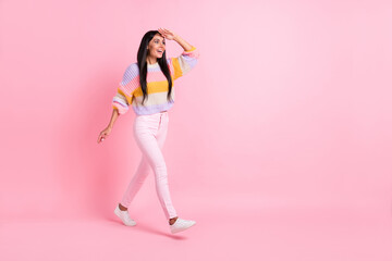 Fototapeta na wymiar Full length body size view of attractive glad cheerful girl walking searching faw way direction isolated over pink pastel color background