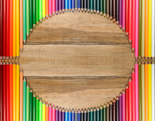 Colored pencils of different colors on wooden background