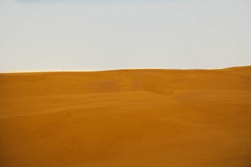 Fototapeta na wymiar Beautiful sand dunes in the Sahara Desert. Moroccan desert landscape with blue sky. Dunes background.