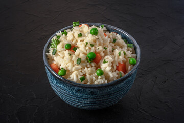 Rice with vegetables on a black background