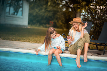 Fototapeta na wymiar Mother and daughter having fun by the pool.