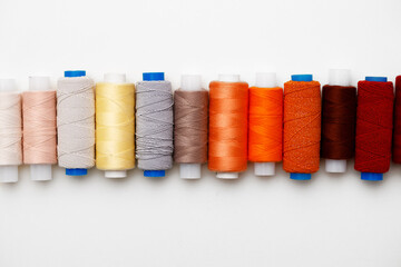 Colored spools of threads on white background