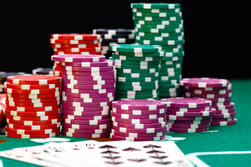 Poker chips and playing cards on black background