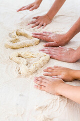 family, a young mother with her daughter and son made a heart out of dough in the kitchen