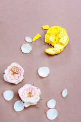 Crushed yellow macaroon and flowers on pink background. Top view. Flat lay.