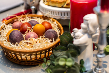 Easter table, basket with painted eggs and cake.