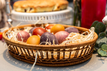 Easter table, basket with painted eggs and cake.