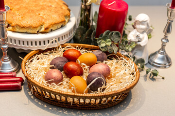 Easter table, basket with painted eggs and cake.