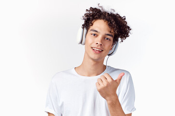 Cheerful man with curly hair in headphones listens to music emotions