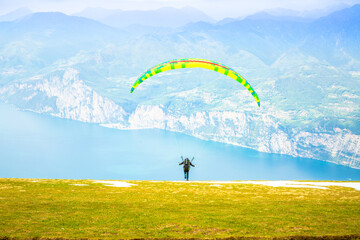 Gleitschirmfliegen am Gardasee mit Bergpanorama im Hintergrund See Paragleiter Italien Sport Berg /...