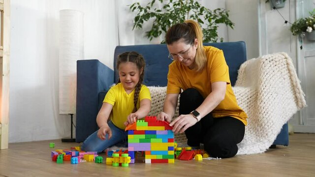 Happy family. Family construction business. Teamwork concept. Happy child is building a house with colored blocks. House construction. Family dream of their own home. Happy dream. Family business