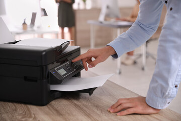Employee using modern printer in office, closeup